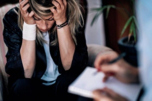 Depressed Prints: Depression, conceptual image. Suicidal female patient in psychotherapy session