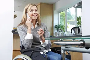 Disability Prints: Disabled Woman In Wheelchair Making Call On Mobile Phone At Home