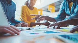 Analytics Prints: Diverse Team Collaborating Around Laptop Screen with Data Visualization in Modern Office Environment