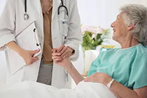 Responsible Prints: Doctor and aging patient holding hands in hospital