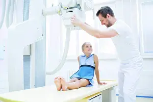 X Ray Prints: Doctor preparing girl for x-ray in hospital