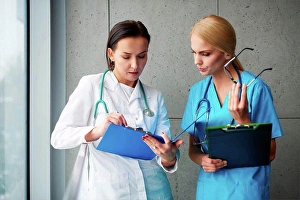 Gifted Prints: Doctor and surgeon talking in hallway, looking at clipboard