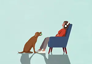 Struggle Prints: Dog with ball sitting in front of oblivious woman with headphones in armchair
