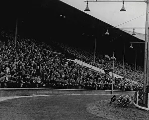 The dogs turning into the straight at Wembley Stadium while the thousands watch and wait. September 2, 1947