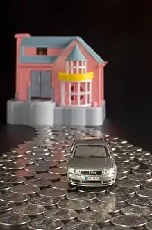 Bill Prints: Doll house and toy car with indian rupee coins in a shape of a road