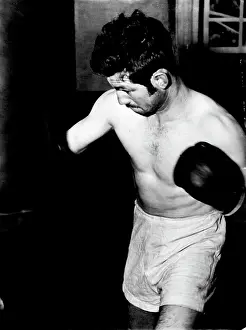 Boxer Prints: Don Johnson shows determination as he punches the bag in training for his return bout with Alf Sands next Monday night