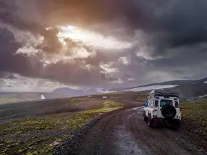 Horizontal Size Prints: Dramatic sky over off-road car driving along remote dirt road at¶ÿFjallabak Nature Reserve