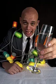Champagne Flute Prints: A drunk man with a string of lights around him holding a glass of champagne