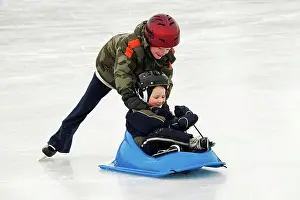 Apparel Prints: edmonton, alberta, canada, a boy pushing a younger boy in a sled on an outdoor ice rink