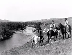 Native Prints: Edward S. Curits Native American Indians - Three Piegan Indians and four horses on hill above river circa 1910