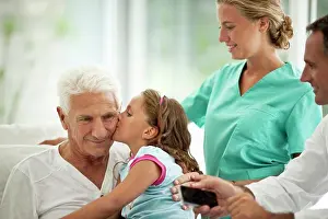 Doctors Prints: Elderly man receiving a hospital visit from his granddaughter