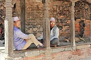 Chic Prints: Two elderly men in traditional dress relax in an old wooden structure