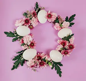 Celebrate Prints: From above elegant Easter wreath made of flowers and chicken eggs and placed on pink background
