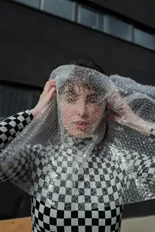 Chic Prints: Emotionless female model in stylish black and white plaid jacket standing