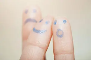 Expressive Prints: Emotions Three fingers with painting of various emotional faces