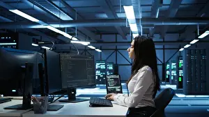 Electronics Prints: Engineer in data center sitting down at desk