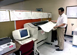 Archives Prints: An engineer monitors a printout as he uses the Computer Aided Design (CAD)