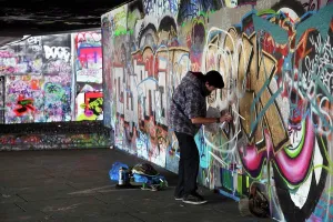 Colourful Prints: England, London, South Bank. A graffiti artist at work in an area known as the under-croft on the South Bank in London