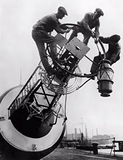 Fitting Prints: England: October 13, 1923 Workmen fitting one of the new 900 candle power petroleum vapor lamps to a coastal buoy