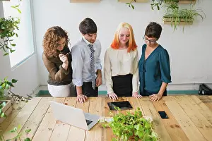 Team Work Prints: Four entrepreneurs looking at a tablet
