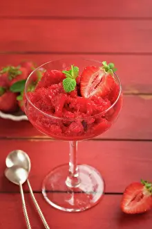 Refreshing Prints: Erdbeer-Granita oder frisches Beeren-Sorbet im Glas auf alten roten Holztisch Hintergrund