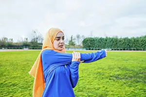 Runner Prints: Ethnic female athlete stretching arms before running training