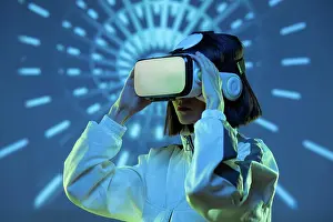 Cyberspace Prints: Excited young woman having virtual reality experience in neon light
