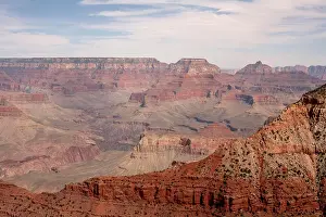 Arid Prints: Expansive view of the Grand Canyon's layered red and orange rock formations under a cloudy sky