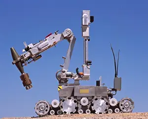 Robot Prints: An Explosive Ordnance Disposal Robot Grips A Mortar Round