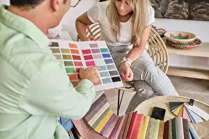 Assortment Prints: fabric salesman shows a lady the color chart