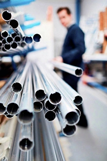 Industrious Prints: Factory worker removing metal rod from shelf in roller blind factory
