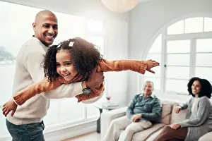 Family, flying and a father playing with his daughter in the living room of their home together during a visit