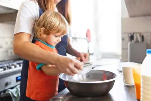 Flour Prints: Family in a kitchen. Mother and child sieving flour into a bowl