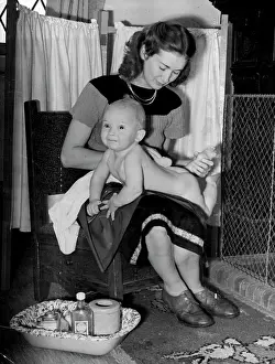 1946 Prints: Family make - up -- Nine-months-old 'extra' Jeremy Hanley gets his first lessons in the use of make-up