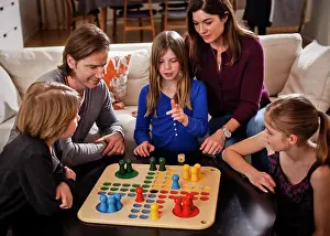 Midadult Men Prints: Family of five playing ludo together at table