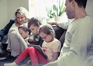 Communications Prints: Family of five sitting on sofa at home