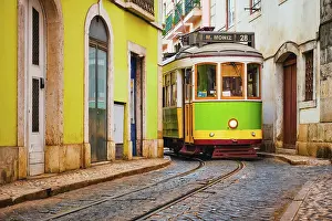 Tram Prints: Famous vintage yellow tram 28 in the narrow streets of Alfama district in Lisbon