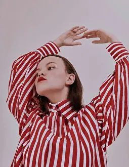 Attractive Prints: Fashion girl. Young brunette woman posing at studio in striped red and white shirt white skirt and trendy sandals