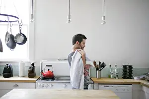 Casual Wear Prints: Father comforting toddler in a cozy kitchen setting