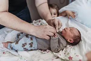 Maternity Prints: Father dressing newborn son to come home from birthing center