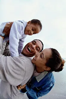 Purestock Prints: Father and mother together with their daughter at the beach