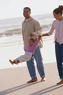 Jeans Prints: Father and mother playing on the beach with their daughter