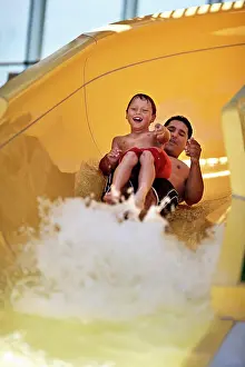 30 To 35 Years Prints: Father and son going down a waterslide together