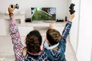 Consumer Electronics Prints: Father and son playing computer game at home