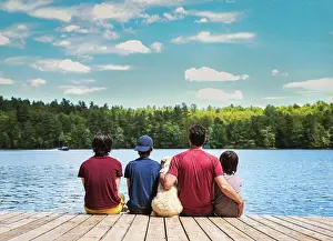 Father Prints: Father, sons and dog sitting on dock on a lake on a sunny summer day