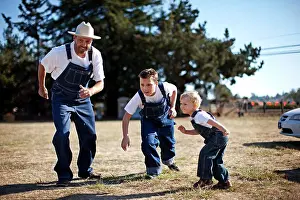 Midadult Men Prints: Father and two sons wearing matching denim overalls about to race