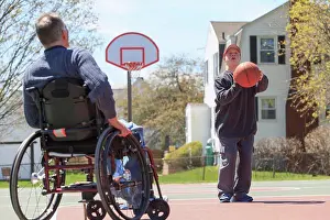 Disorder Prints: Father with Spinal Cord Injury and his son with Down Syndrome playing basketball in a park