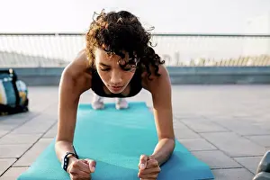 Equilibrium Prints: Female athlete exercising in plank position on exercise mat