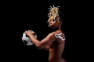 Expressive Prints: Female athlete with painted wings on her back holding a soccer ball
