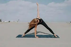 Grownups Prints: Female athlete practicing yoga on exercise mat at beach